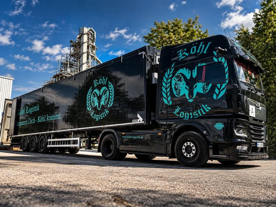 Schwarzer Sattelzug der Köhl Logistik GmbH vor einer Industrieanlage